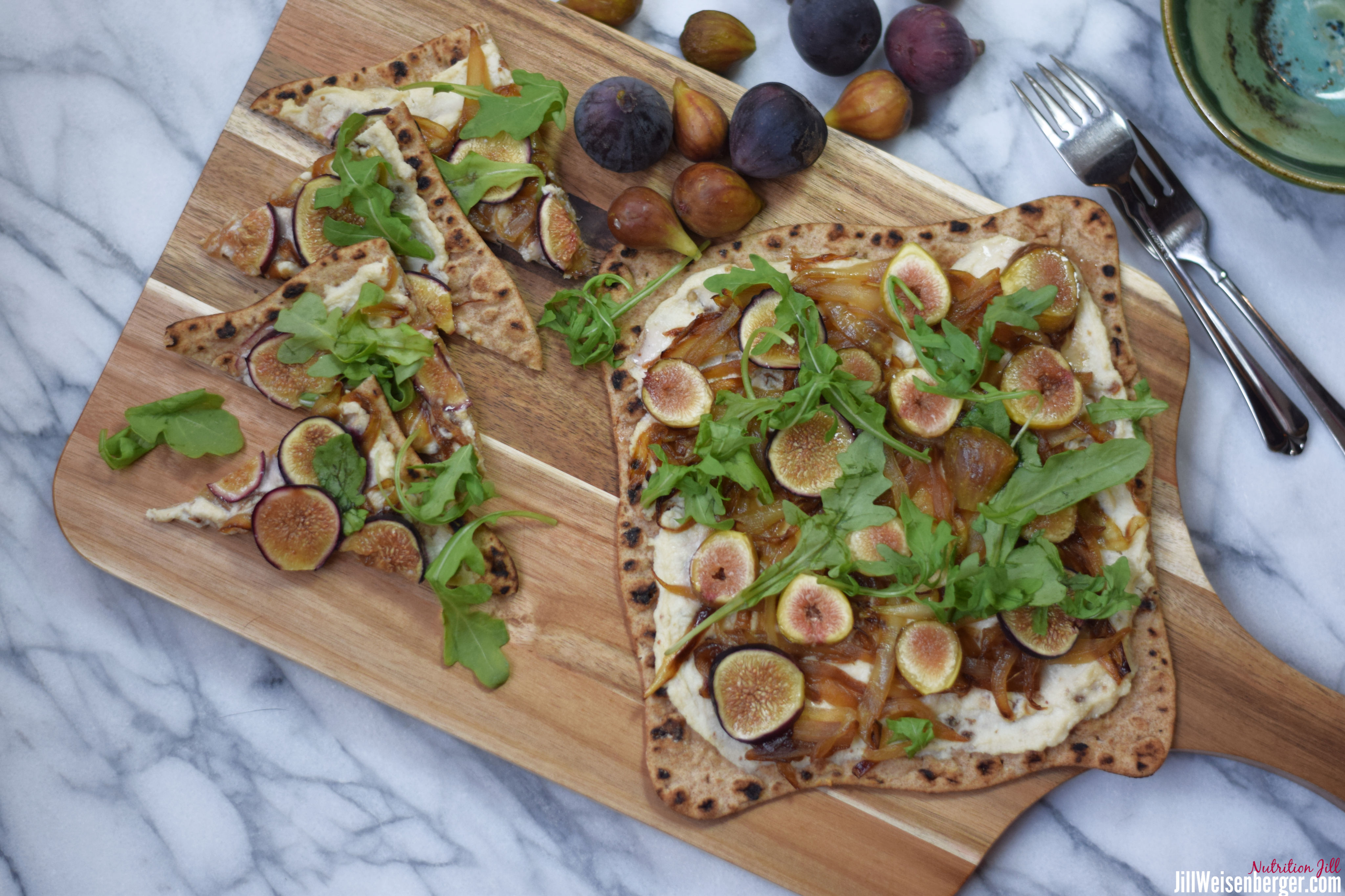Ricotta caramelized onion and fig flatbread on a wooden board