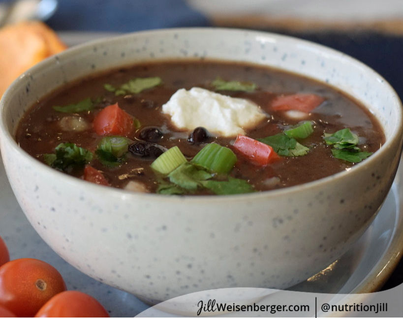 Bowl of vegetarian black bean soup topped with herbs