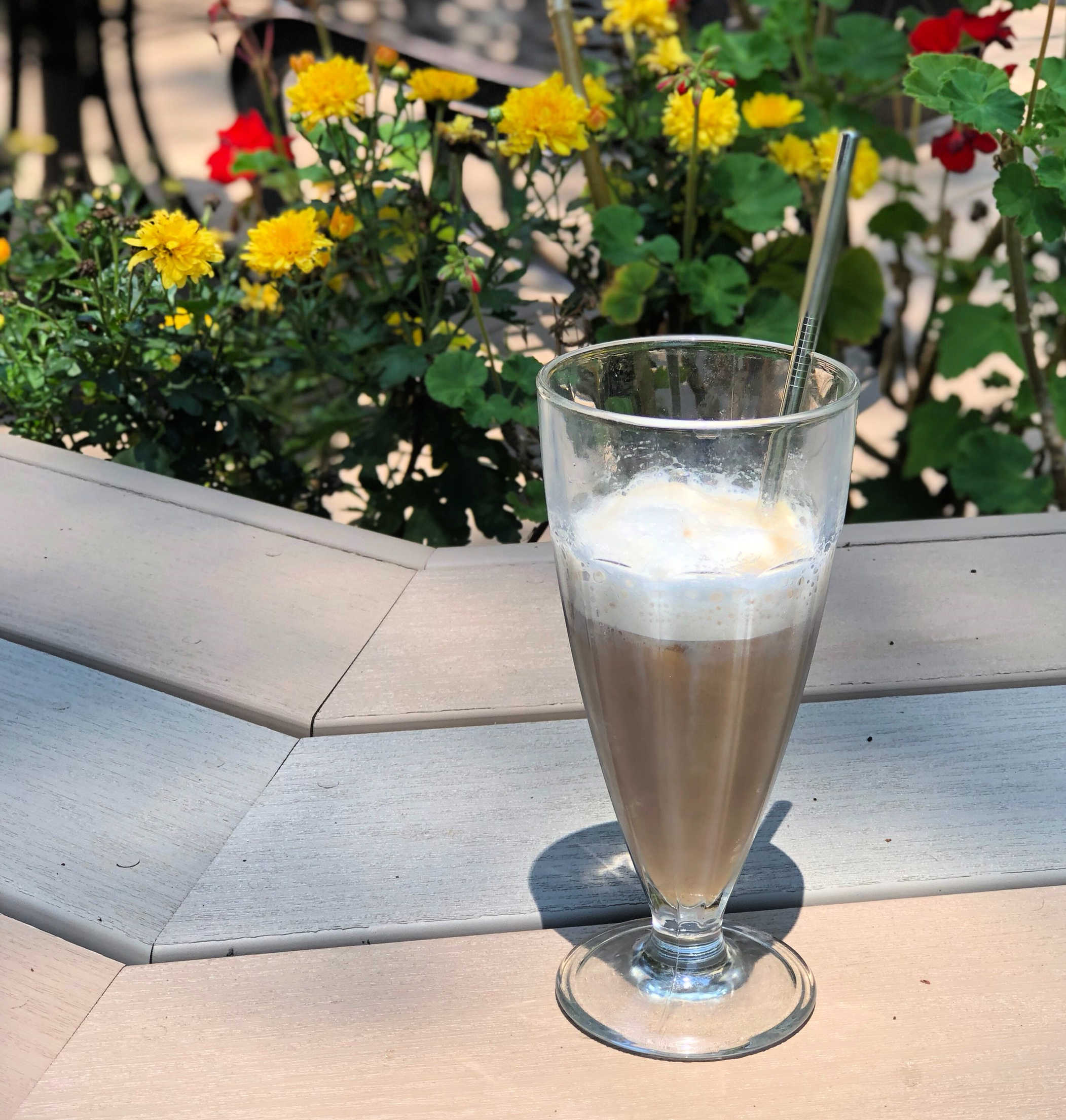 healthy iced latte in front of a flower pot