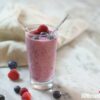 Smoothie with berries in a glass with a spoon